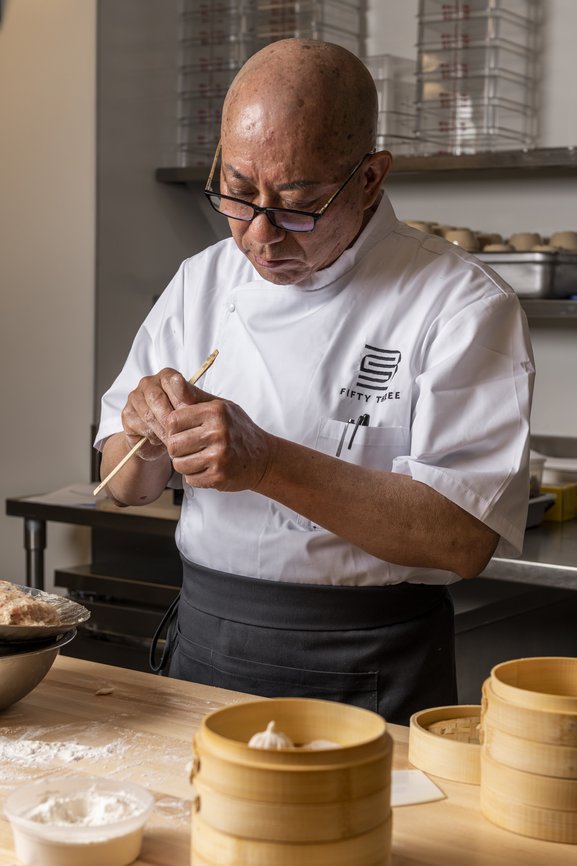A chef standing and making food