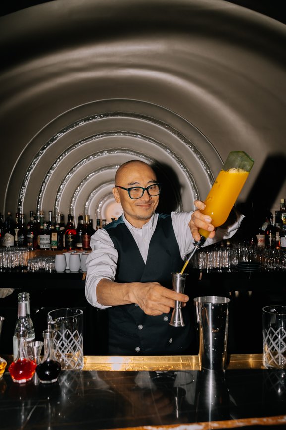Image of a bartender pouring a drink
